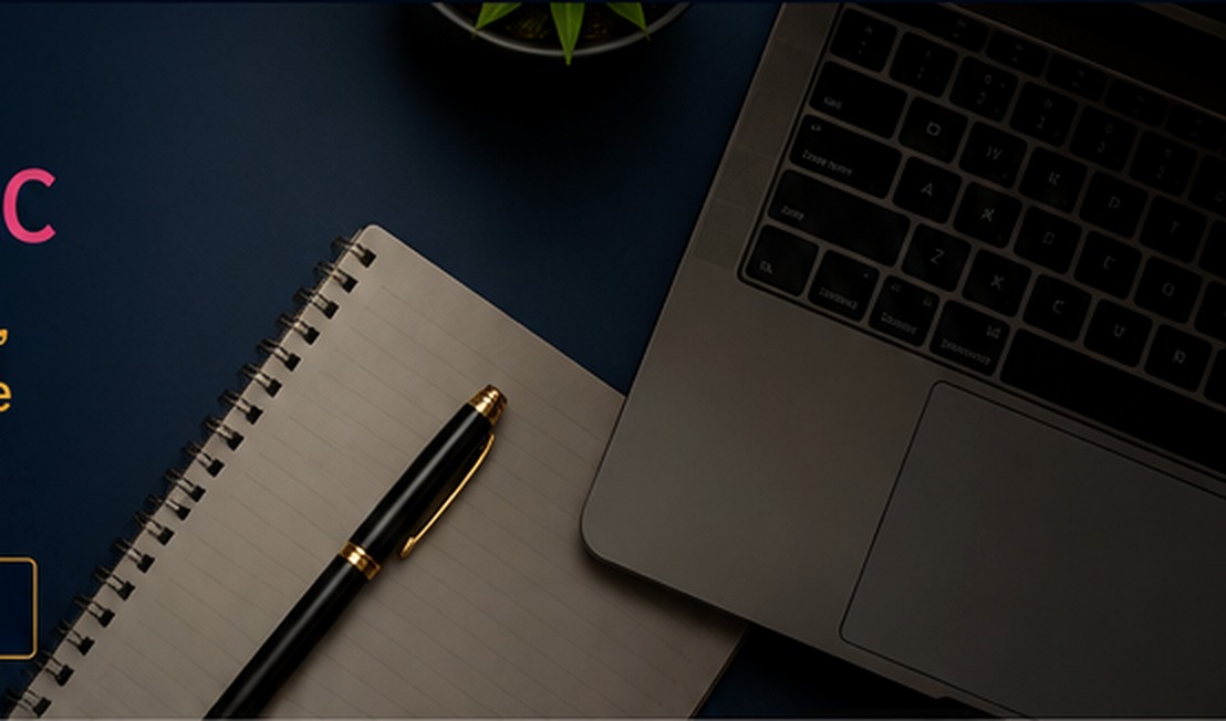 Professional workspace with a laptop, spiral notebook, and black-and-gold pen